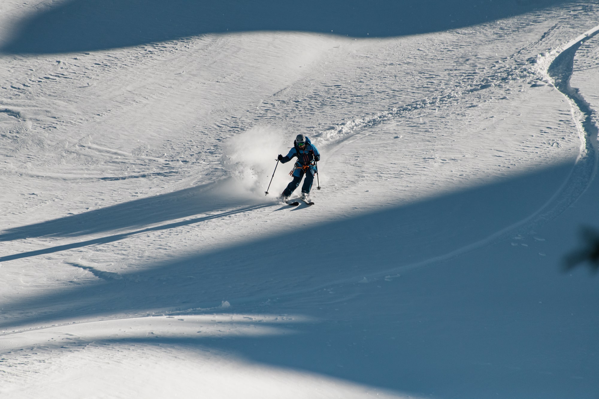 Skier on powdery downhill.