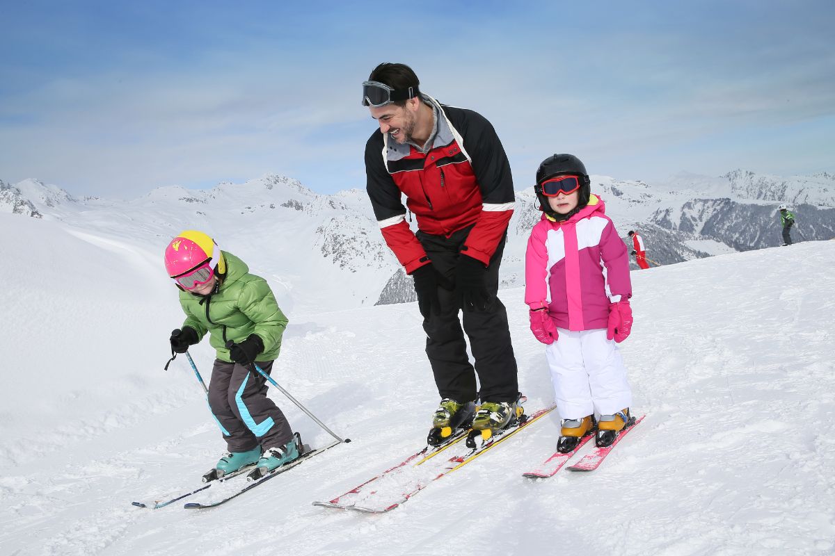 Ski teacher instructed kids on proper skiing position. 