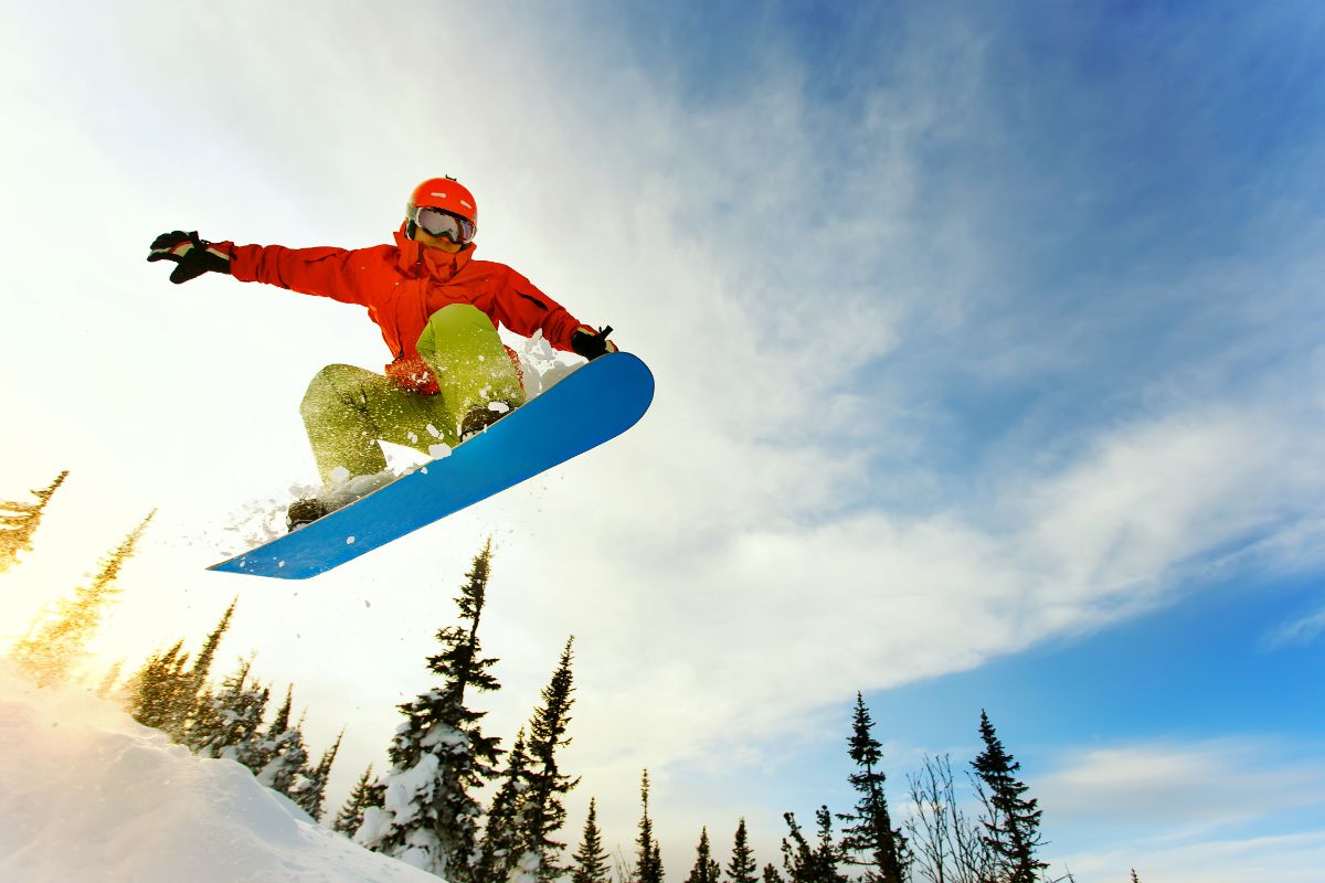 A snowboarder jumping on terrain.